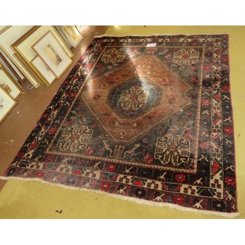 904 - An early 20th century Persian rug (hand made in Iran). Central diamond pattern on fawn ground with 4... 