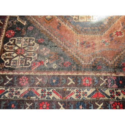 904 - An early 20th century Persian rug (hand made in Iran). Central diamond pattern on fawn ground with 4... 