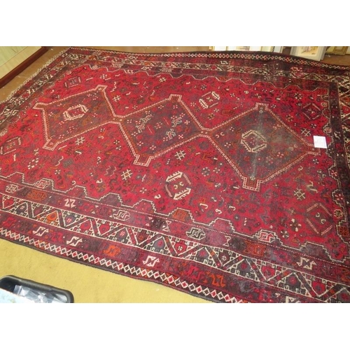 905 - A mid 20th century Persian carpet. 3 repeat central motifs with stylised birds on a claret field. So... 