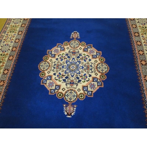 911 - A Moroccan late 20th century wool carpet, central cream motif on a deep blue ground and cream patter... 