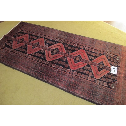 913 - North East Persian Meshed Belouch rug. Central repeat pattern on black ground with a wide slightly f... 