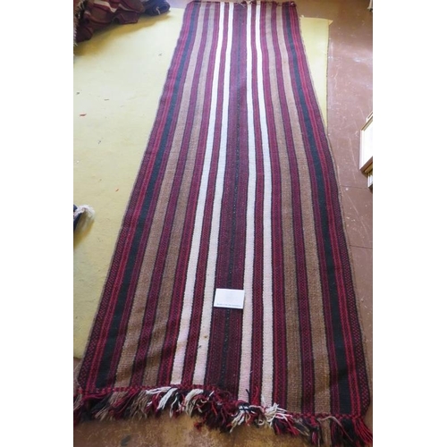 925 - A mid - late 20th century Afghan rug/runner, red/brown, black and white stripe. 310cm x 94cm.
Condit... 