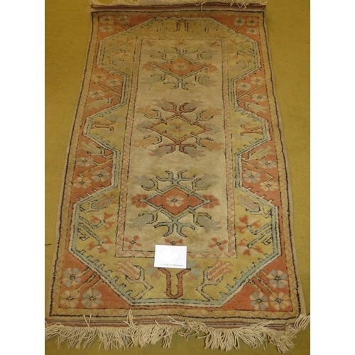 933 - A late 20th century wool rug. Pastel shades. 135cm x 82cm. In good condition.