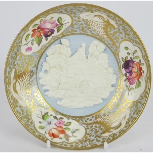 10 - An early 19th century porcelain trio of saucer, tea and coffee cups, each with cottage scene relief ... 