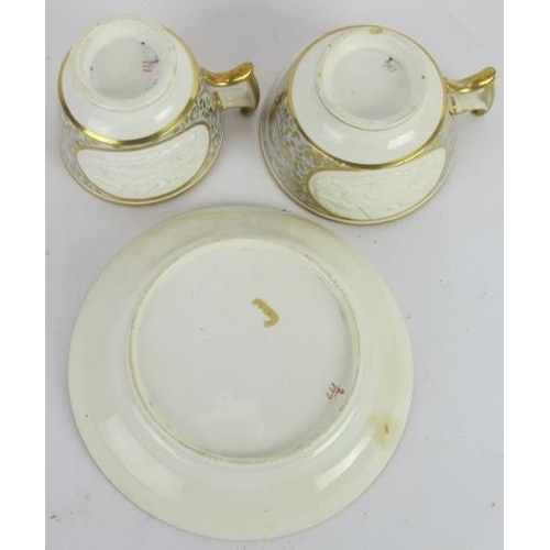 10 - An early 19th century porcelain trio of saucer, tea and coffee cups, each with cottage scene relief ... 