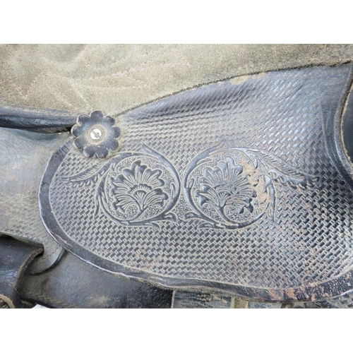 160 - A black leather western style horse riding saddle with tooled patterns, nickel conchos and sheepskin... 