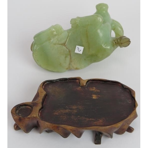 208 - A Chinese carved celadon Jade recumbent water Buffalo, Ming style but likely Qing, resting on a besp... 