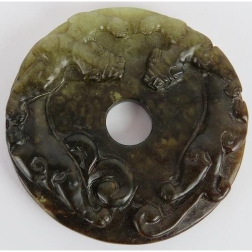 232 - A Chinese carved dark spinach/celadon Jade disc, Ming style but likely Qing, 6.5cm diameter.
Provena... 