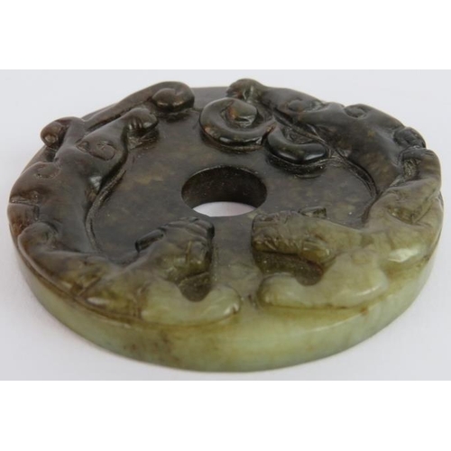 232 - A Chinese carved dark spinach/celadon Jade disc, Ming style but likely Qing, 6.5cm diameter.
Provena... 