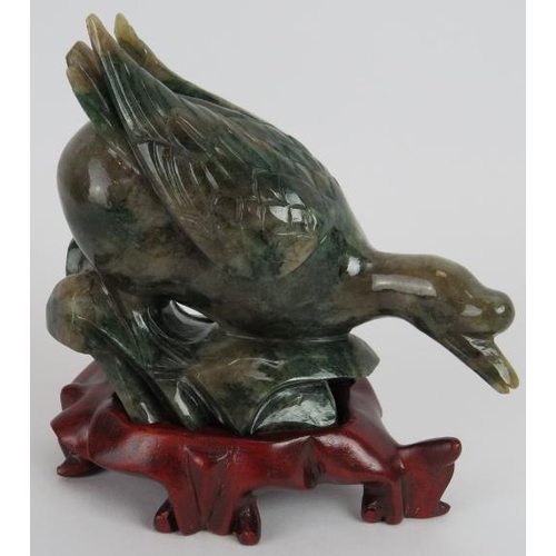 235 - A Chinese carved Mottled spinach Jade duck on a naturalist base, Ming style but likely 20th century,... 