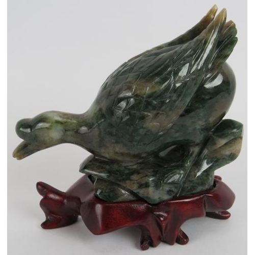 235 - A Chinese carved Mottled spinach Jade duck on a naturalist base, Ming style but likely 20th century,... 