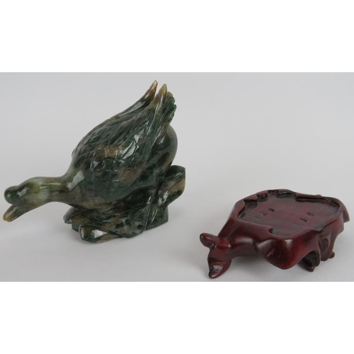 235 - A Chinese carved Mottled spinach Jade duck on a naturalist base, Ming style but likely 20th century,... 