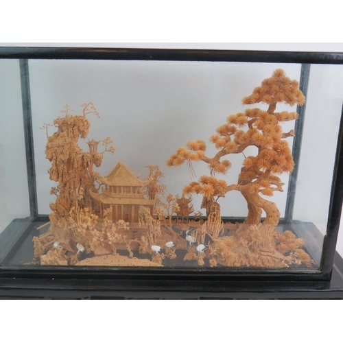 260 - A Chinese carved cork diorama of a traditional pagoda scene in a glazed black lacquered case and sta... 