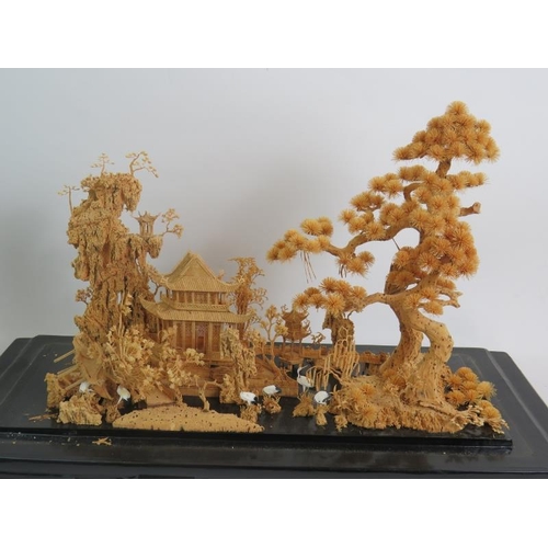 260 - A Chinese carved cork diorama of a traditional pagoda scene in a glazed black lacquered case and sta... 