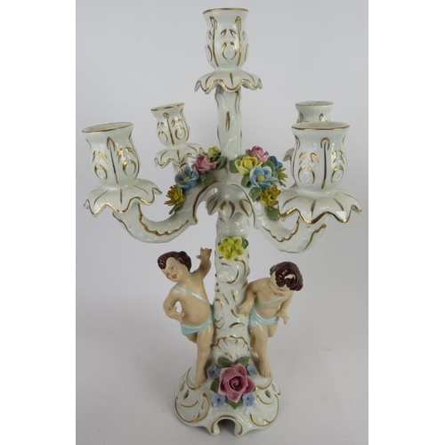 283 - A pair of hand decorated Dresden porcelain four branch candelabra with Putti decoration and a simila... 