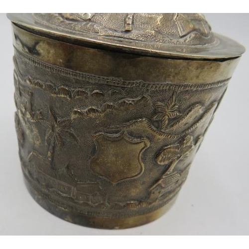 306 - A white metal round lidded Indian box. Embossed with trees, houses and temples. 4.6 troy oz/142 gram... 