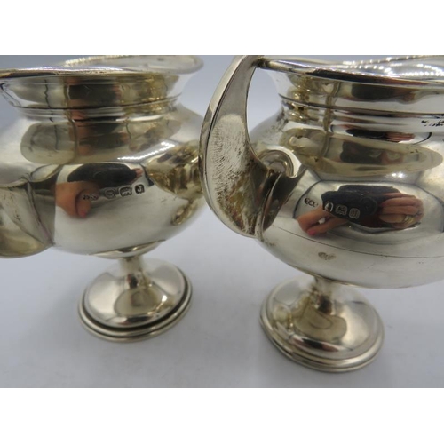 314 - A pair of bulbous two handled pedestal silver vases. Approx: 4