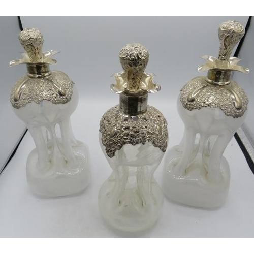 319 - A set of three Edwardian silver mounted pinched glass decanters with original silver mounted stopper... 