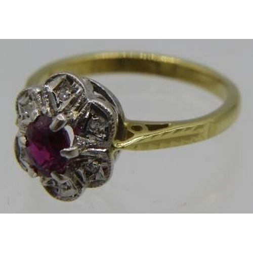 331 - An 18ct yellow and white gold ruby cluster ring. The centre ruby approx 4mm x 3mm with six small sur... 