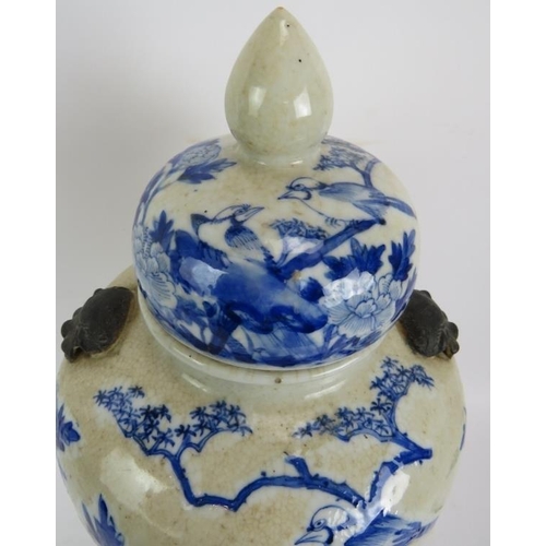 42 - A 19th century Chinese blue and white crackle ware porcelain vase and cover in the Kangxi style pain... 