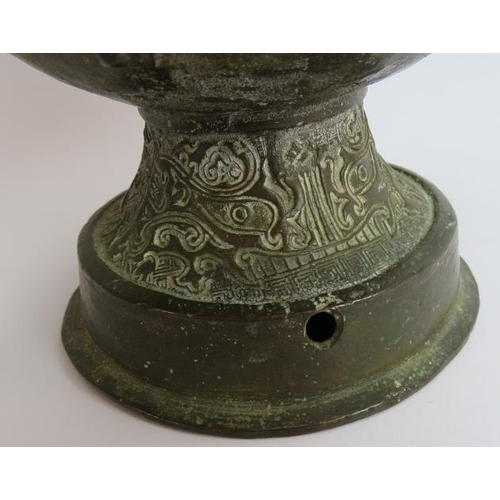 50 - An antique Chinese bronze vase in the Archaic style decorated with dragons and with lion mask handle... 