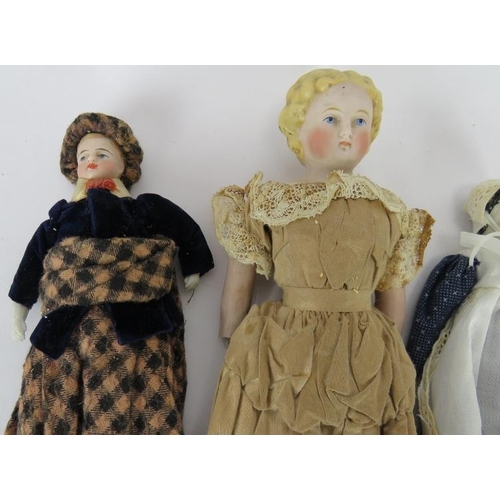 63 - Four 19th century porcelain headed dolls, one in silk dress, one in Highland dress. Tallest: 30cm. (... 