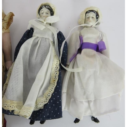 63 - Four 19th century porcelain headed dolls, one in silk dress, one in Highland dress. Tallest: 30cm. (... 