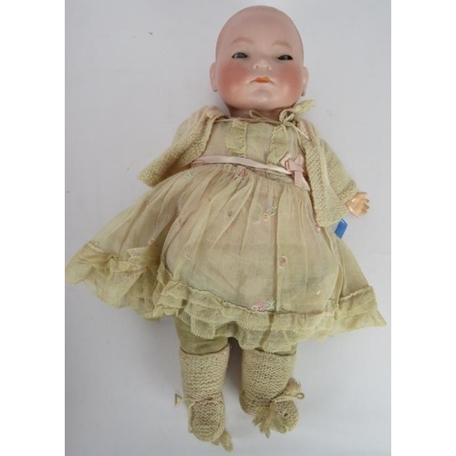 64 - A 1920's BYE-LO baby doll in period outfit with Moses basket. Head marke +IV. Height: 38cm.
Conditio... 