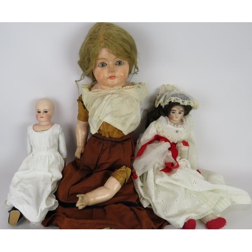 73 - A large antique wax faced doll with leather body (76cm) and two smaller bisque headed dolls. Plus so... 