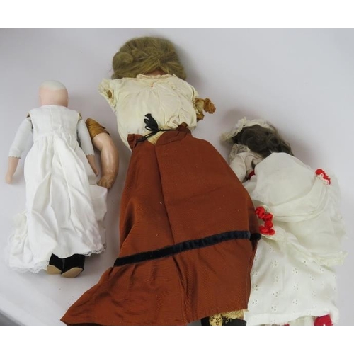 73 - A large antique wax faced doll with leather body (76cm) and two smaller bisque headed dolls. Plus so... 