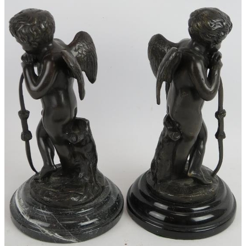 86 - A pair of contemporary bronze cupid figures mounted on black marble bases. Signed indistinctly. Heig... 