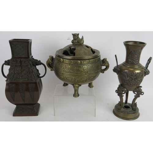 90 - Two Chinese bronze censers, one with cover, a bronze temple bell and two bronze vases, one on carved... 