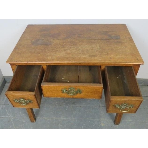 708 - An 18th century medium oak lowboy, housing three cock-beaded drawers with brass swan-neck handles an... 