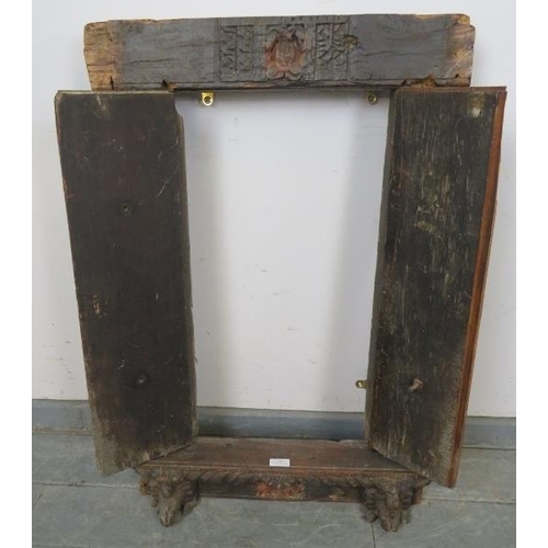 713 - An antique hardwood shuttered window, with relief carving and cast-iron fittings, featuring carved c... 