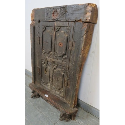 713 - An antique hardwood shuttered window, with relief carving and cast-iron fittings, featuring carved c... 