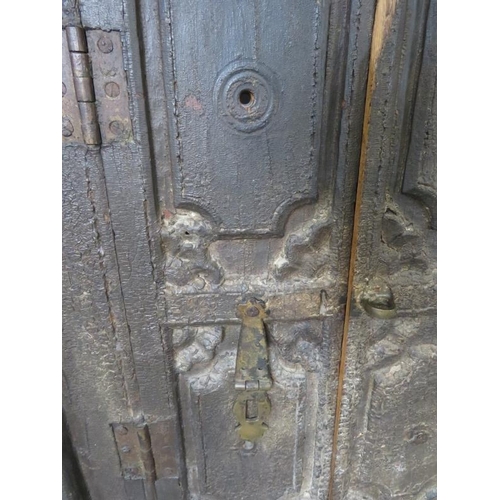 713 - An antique hardwood shuttered window, with relief carving and cast-iron fittings, featuring carved c... 