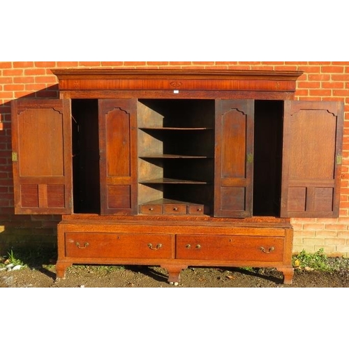 718 - A large 18th century Welsh oak livery cupboard, the inlaid cornice featuring a central butterfly, ab... 