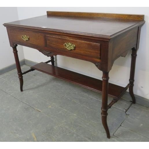 722 - An Edwardian mahogany writing table, housing two short drawers with fancy brass handles, on tapering... 