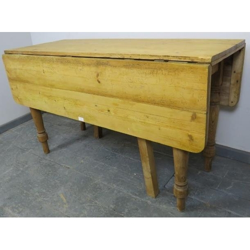 724 - An antique stripped pine drop-leaf kitchen table, with gate-leg action, on baluster turned supports.... 