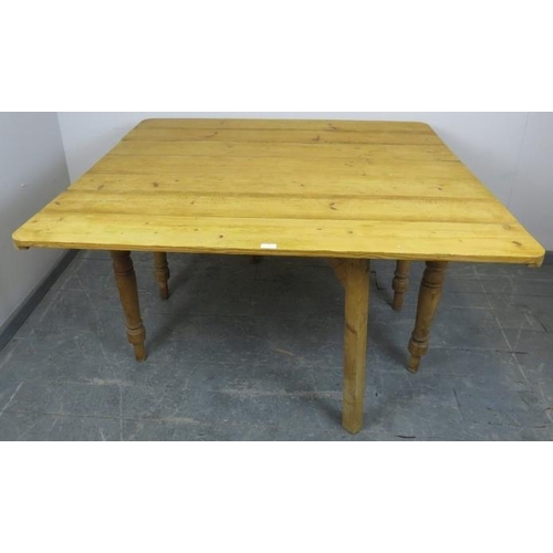 724 - An antique stripped pine drop-leaf kitchen table, with gate-leg action, on baluster turned supports.... 