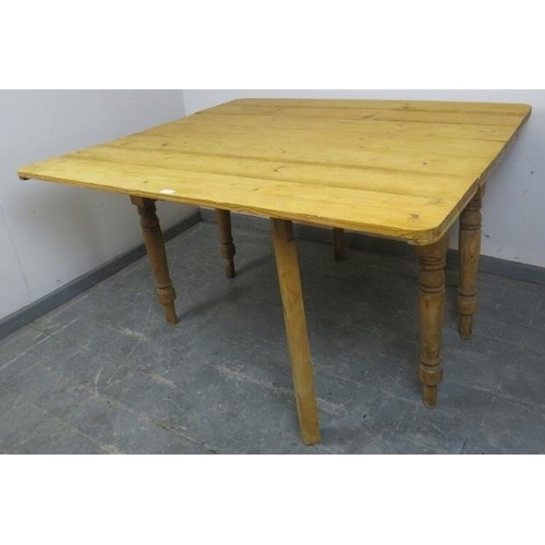 724 - An antique stripped pine drop-leaf kitchen table, with gate-leg action, on baluster turned supports.... 