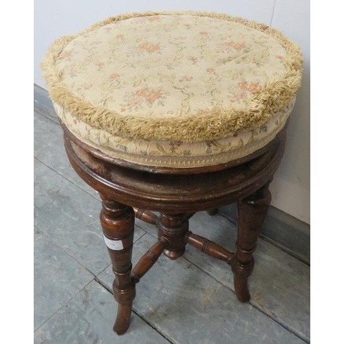 739 - A turn of the century walnut height adjustable music stool, with tapestry seat, on turned tapering s... 