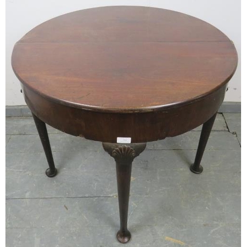 744 - A Georgian Cuban mahogany demi-lune turnover tea table, with shell carved knees, on tapering support... 