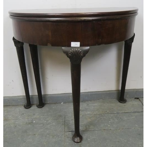 744 - A Georgian Cuban mahogany demi-lune turnover tea table, with shell carved knees, on tapering support... 