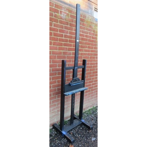 759 - A vintage oak height adjustable artist’s easel, painted black, on splayed supports with castors. 
Co... 