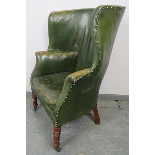 764 - An Edwardian Georgian Revival barrel back armchair, upholstered in distressed green leather with bra... 