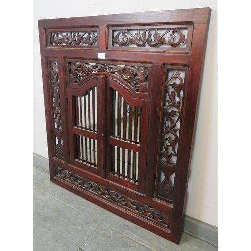 784 - A vintage mahogany wall mirror with foliate carved and pierced surround and double shutter doors wit... 