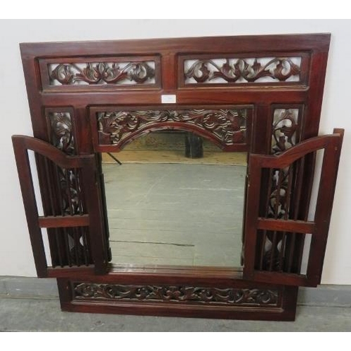 784 - A vintage mahogany wall mirror with foliate carved and pierced surround and double shutter doors wit... 