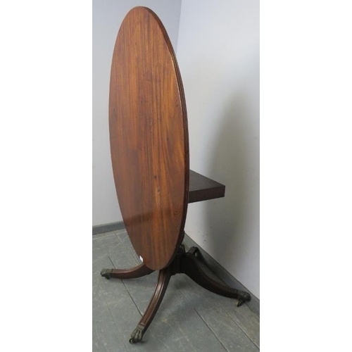 803 - A Regency Cuban mahogany oval tilt-top breakfast table, with reeded edge, on a turned column with fo... 