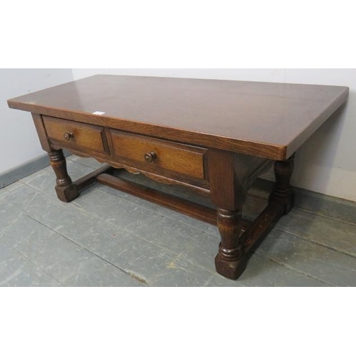 804 - A reproduction heavy oak coffee table, housing two short drawers with turned wooden knob handles, on... 